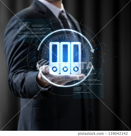 A businessman in a suit holds a glowing digital hologram representing organized folders and document management systems, symbolizing efficient data storage and archiving solutions A businessman in a suit holds a glowing digital hologram representing organized folders and document management systems, symbolizing efficient data storage and archiving solutions 139042142