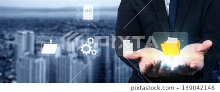 Businessman presenting a digital document management system with folder, gear, and chart icons, representing business process automation and data storage in a modern city 139042148