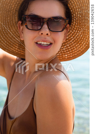 Portrait Of Beautiful Woman In Straw Hat At Beach. Sun Protection Concept. Summer Skincare And Beauty Lifestyle At Sea 139042658