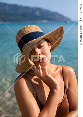 Beautiful Woman Touching Face With Eyes Closed At Beach. Beauty Relax Skincare Concept. Female Enjoying Sunlight On Skin Beautiful Woman Touching Face With Eyes Closed At Beach. Beauty Relax Skincare Concept. Female Enjoying Sunlight On Skin 139042695