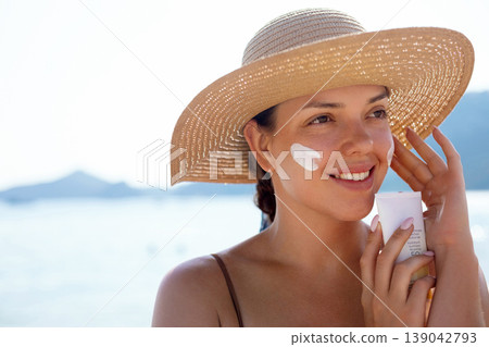 Pretty Woman Holding Sunscreen And Smiling At Beach. Beauty Skincare Routine. Female Using Sun Cream For Skin Protection 139042793