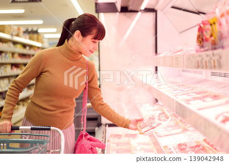 一位女士在超市肉品區購物。 一位女士在超市肉品區購物。 139042948