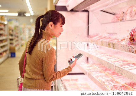 一位女士在超市肉品區購物。 139042951