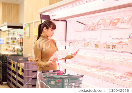 一位女士在超市肉品區購物。 一位女士在超市肉品區購物。 139042956