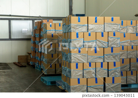 Stacks of cardboard boxes in industrial warehouse. Stacks of cardboard boxes in industrial warehouse. 139043011