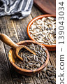 Sunflower Seeds in Wooden Bowls With Scoop on Rustic Tabletop. Snack and Healthy Seed Food 139043034