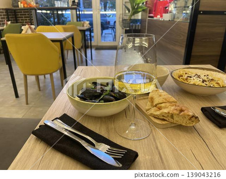 a table with a bowl of food and a glass of wine a table with a bowl of food and a glass of wine 139043216
