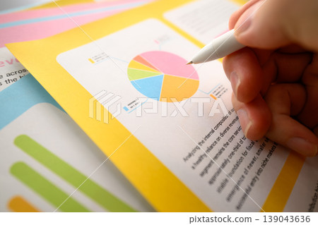 一隻手拿著筆指向圖表 一隻手拿著筆指向圖表 139043636
