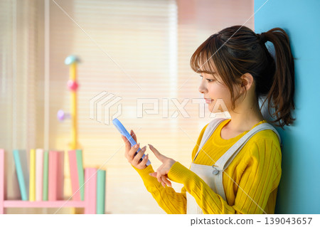 A young woman operating her smartphone: Happy Pop 139043657