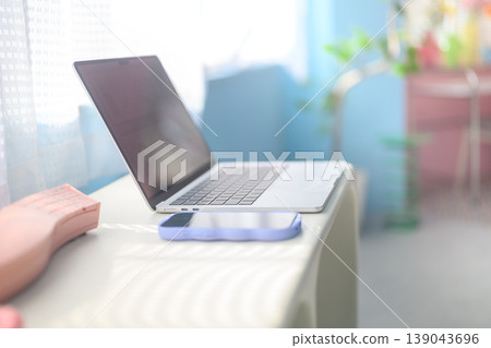 A laptop and smartphone placed on a desk by the window: Happy Pop 139043696