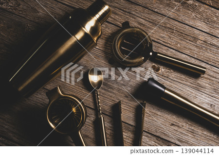 Luxury Golden Barware Set for Mixology on Wood Background. Luxury Golden Barware Set for Mixology on Wood Background. 139044114