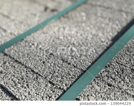 Close-up of textured concrete surface with green steel bands used for construction element background 139044229