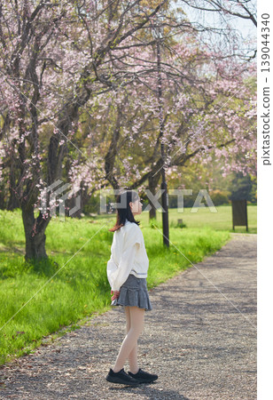 春天,一位國中女生帶著她可愛的博美犬,在櫻花盛開的公園裡欣賞櫻花。 春天,一位國中女生帶著她可愛的博美犬,在櫻花盛開的公園裡欣賞櫻花。 139044340