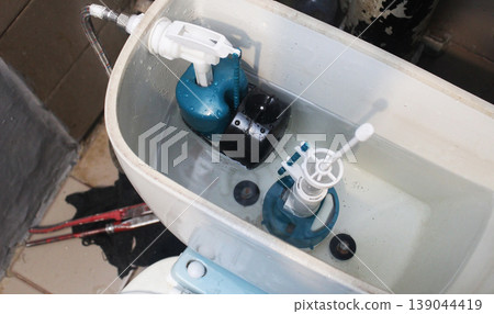Installed toilet tank flush mechanism Installed toilet tank flush mechanism 139044419