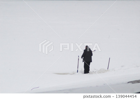 the danger of being on ice. Lonely fisherman on the river the danger of being on ice. Lonely fisherman on the river 139044454
