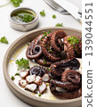 Boiled octopus on ceramic plate with olive oil and parsley dressing. Mediterranean cold appetizer 139044551