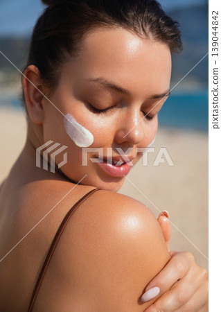 Pretty Woman With Closed Eyes And Sunscreen On Face At Beach. Beauty Skincare And Sun Protection Concept Pretty Woman With Closed Eyes And Sunscreen On Face At Beach. Beauty Skincare And Sun Protection Concept 139044842