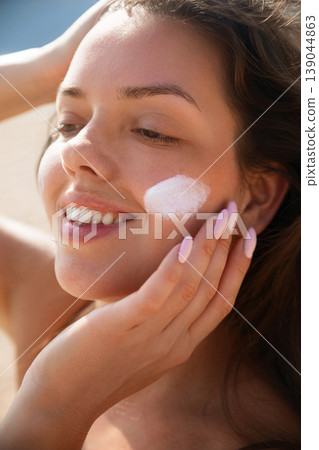 Pretty Woman Touching Cheek With Sunscreen On Face At Beach Portrait. Beauty Skincare And Sun Protection Concept Pretty Woman Touching Cheek With Sunscreen On Face At Beach Portrait. Beauty Skincare And Sun Protection Concept 139044863