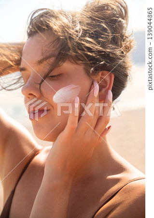 Beautiful Woman With Closed Eyes And Sunscreen On Face At Beach. Beauty Skincare And Sun Protection Concept Beautiful Woman With Closed Eyes And Sunscreen On Face At Beach. Beauty Skincare And Sun Protection Concept 139044865