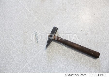 a hammer and a nail on a white background. The concept of no construction tools a hammer and a nail on a white background. The concept of no construction tools 139044915
