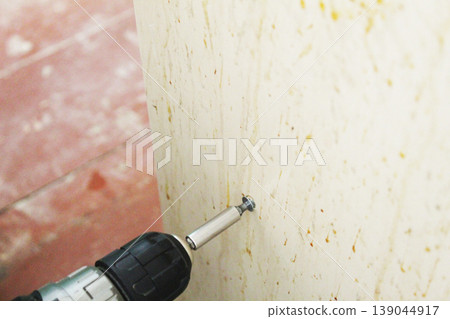 Master man tightening screw with a screwdriver 139044917