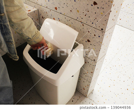 Guy throwing away a napkin in the toilet Guy throwing away a napkin in the toilet 139044936