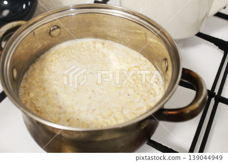 A pot of porridge stands on a gas stove A pot of porridge stands on a gas stove 139044949