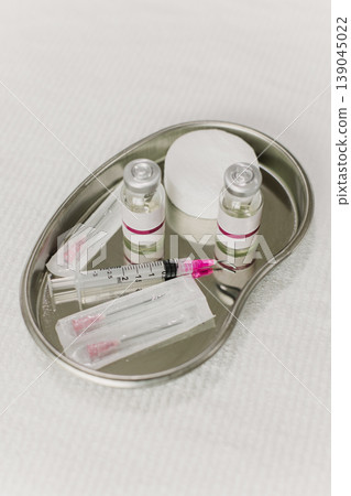 A metal tray with cosmetic instruments and ampoules on a white background. Cosmetology concept. A metal tray with cosmetic instruments and ampoules on a white background. Cosmetology concept. 139045022