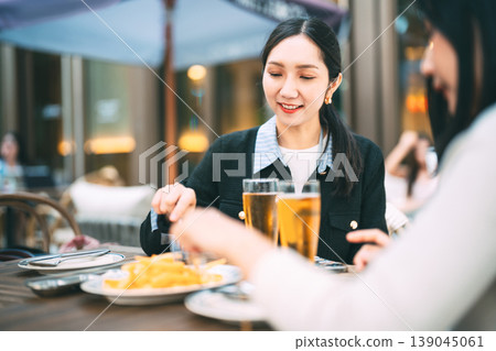 Two young adult asian business women enjoy eating dinner together on night at restaurant Two young adult asian business women enjoy eating dinner together on night at restaurant 139045061