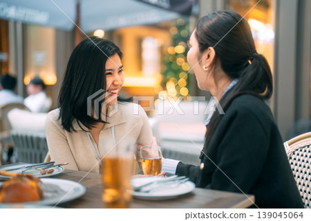 Two young adult asian business women enjoy eating dinner together on night at restaurant Two young adult asian business women enjoy eating dinner together on night at restaurant 139045064