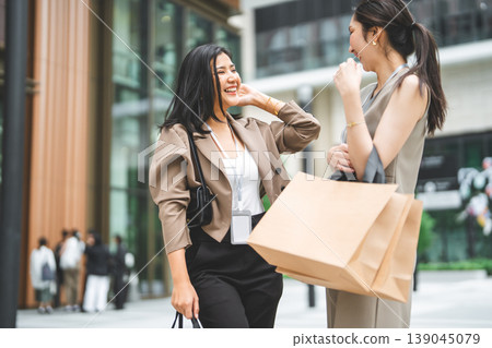 Two business women holding shopping bag happy spending salary money together 139045079