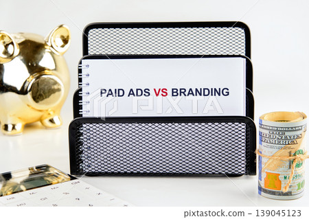 A white spiral notebook in a black mesh organizer highlights PAID ADS VS BRANDING 139045123