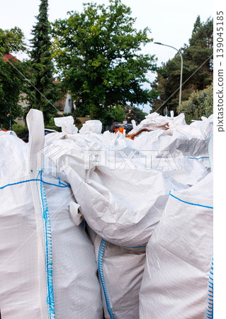Close up of construction waste materials packed into white woven bulk sacks, stacked outdoors at a work site Close up of construction waste materials packed into white woven bulk sacks, stacked outdoors at a work site 139045185