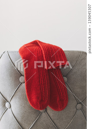 Hand knitted socks on a grey background. Concept for handmade and hygge slow life. Hand knitted socks on a grey background. Concept for handmade and hygge slow life. 139045307