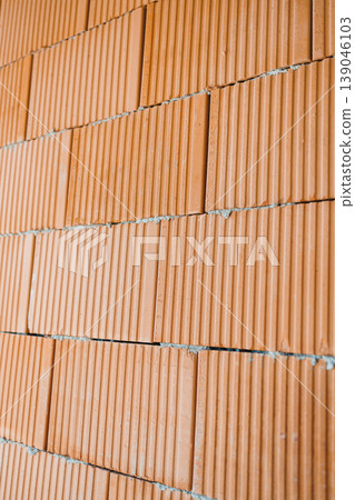Construction workers build a wall using red bricks in a residential area during daylight hours in the summer season Construction workers build a wall using red bricks in a residential area during daylight hours in the summer season 139046103