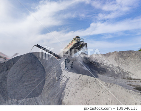 Granite quarry site with machinery processing stone at work during the day under a blue sky and some clouds 139046113