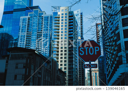 City street view with tall buildings and a stop sign during daytime showing a busy urban setting in a metropolitan area City street view with tall buildings and a stop sign during daytime showing a busy urban setting in a metropolitan area 139046165