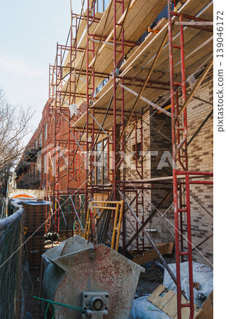 Construction site in a city with scaffolding and building materials during daytime work hours in a developing residential area Construction site in a city with scaffolding and building materials during daytime work hours in a developing residential area 139046172