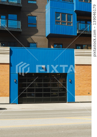 Building design shows modern style with blue and brown colors near a street in a busy urban area during daylight hours 139046179