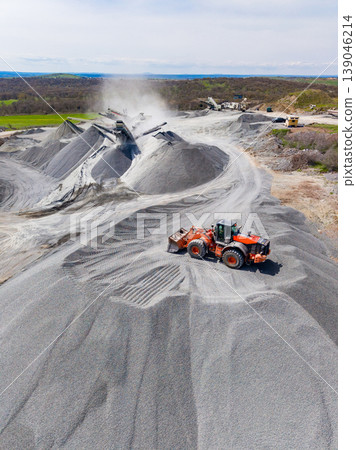 Granite quarry operation with machinery moving stone and processing materials during daylight Granite quarry operation with machinery moving stone and processing materials during daylight 139046214