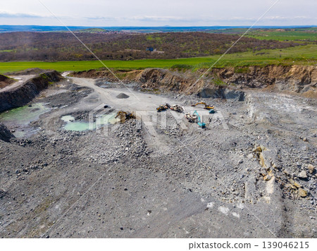 Granite quarry site with machinery and raw materials in a rural landscape during daytime Granite quarry site with machinery and raw materials in a rural landscape during daytime 139046215