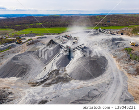Large granite quarry operation with machinery processing stone in an outdoor site during daytime Large granite quarry operation with machinery processing stone in an outdoor site during daytime 139046221
