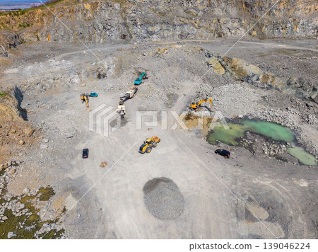 Granite quarry site showing heavy machinery operating during daylight at a remote location with large rocks and excavated areas Granite quarry site showing heavy machinery operating during daylight at a remote location with large rocks and excavated areas 139046224