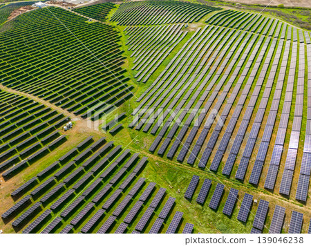 Rows of solar panels in a large field near a rural area during a sunny day with clear skies and no clouds 139046238