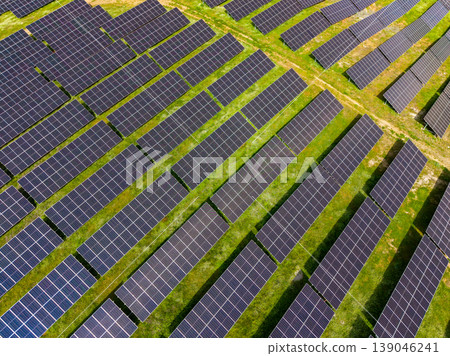 Large solar farm with rows of solar panels in an open field during daytime 139046241