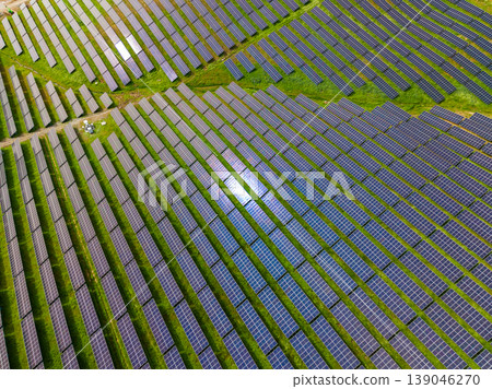 Solar panels cover large area in agricultural field showcasing renewable energy usage during bright daylight in a rural setting Solar panels cover large area in agricultural field showcasing renewable energy usage during bright daylight in a rural setting 139046270