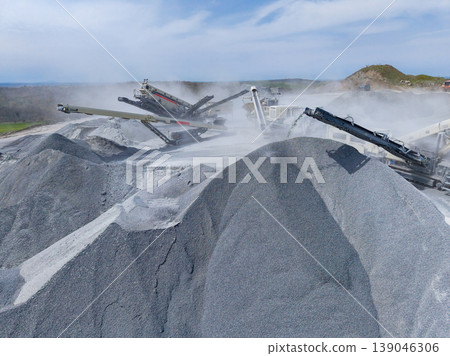 Granite quarry showing machinery and large piles of crushed stone during rock processing in daylight Granite quarry showing machinery and large piles of crushed stone during rock processing in daylight 139046306