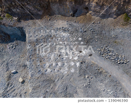 Granite quarry seen from above with marked sections for stone extraction and machinery paths in a rugged landscape during daylight Granite quarry seen from above with marked sections for stone extraction and machinery paths in a rugged landscape during daylight 139046390