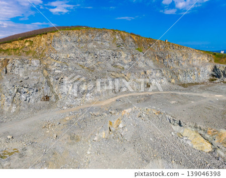 Granite quarry located in a rural area with rock formations and clear blue sky during daylight hours 139046398