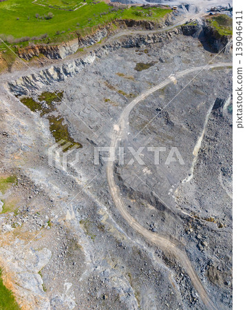 Granite quarry showing rock formations, paths, and equipment in an active mining area during daylight hours 139046411